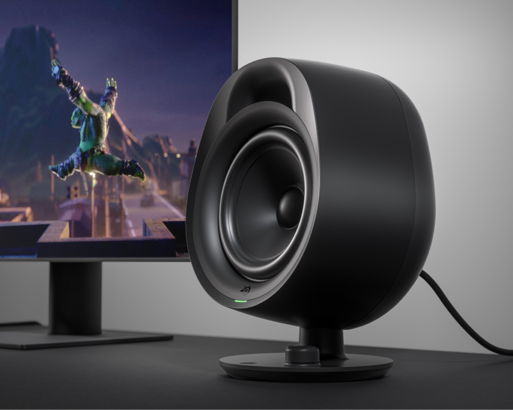 Gaming speaker on a desk with a monitor in the background.