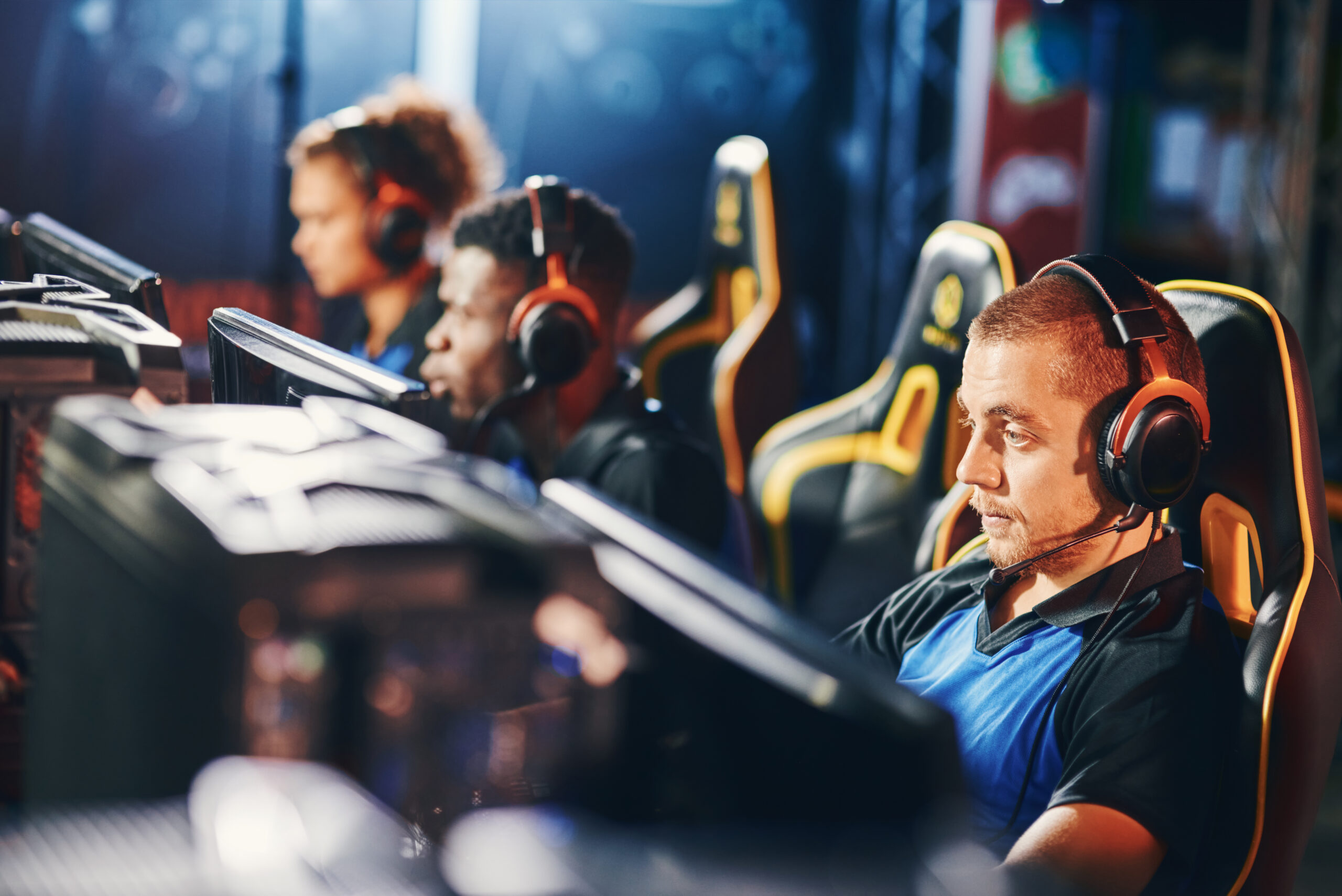 Focused on game. Male cybersport gamer wearing headphones playing online video games, participating in eSport tournament