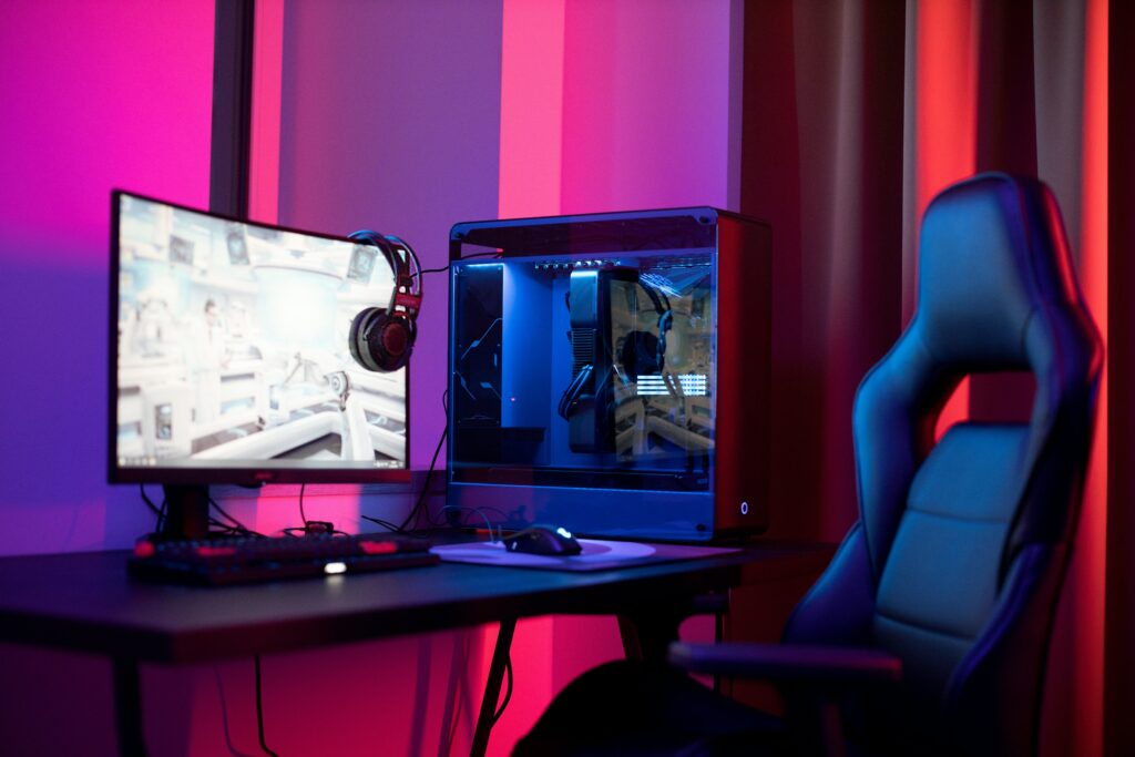 Gaming desk with chair and peripherals in a red and violet color mood.