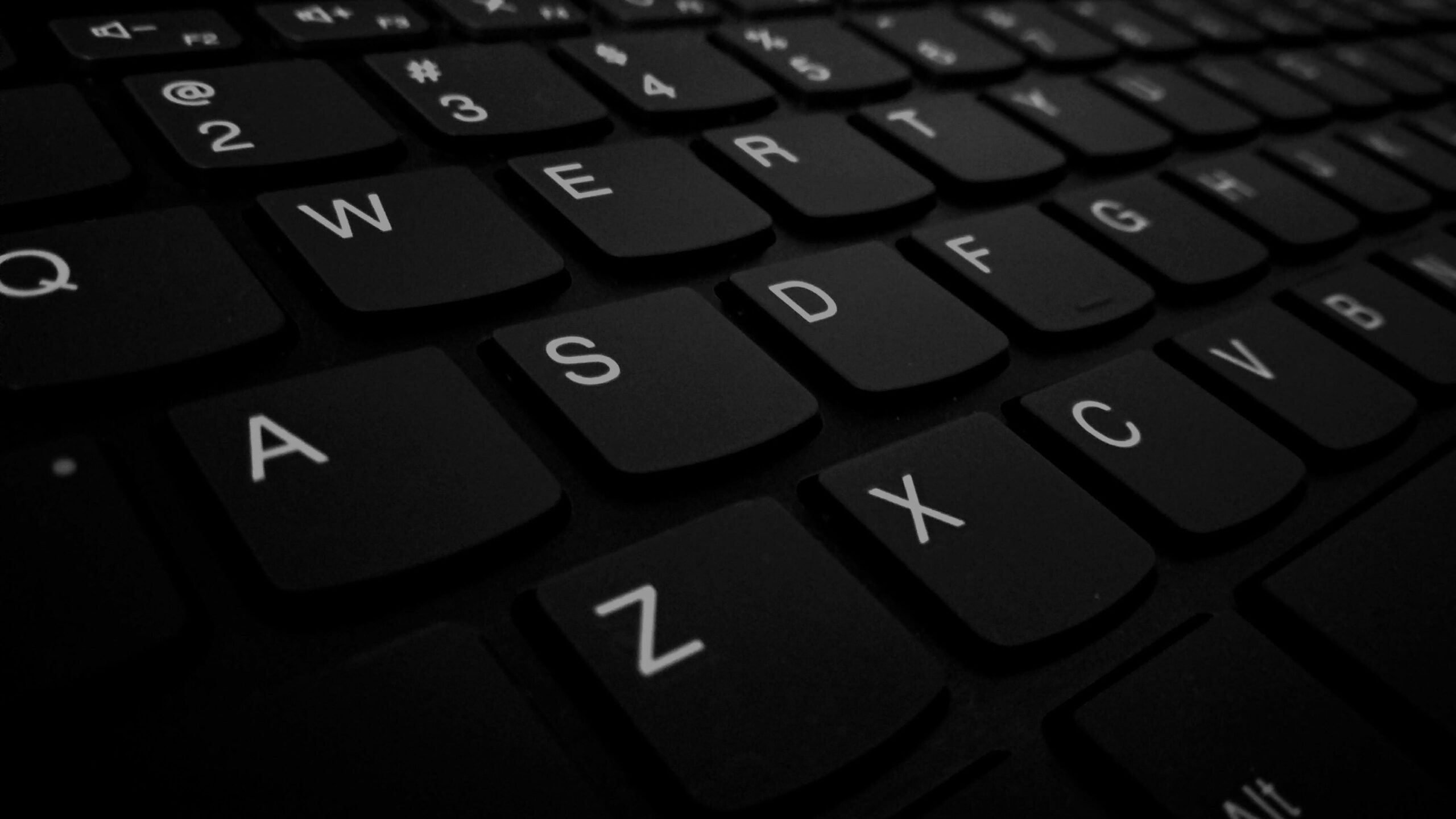 Zoomed in keys of a black membrane keyboard.