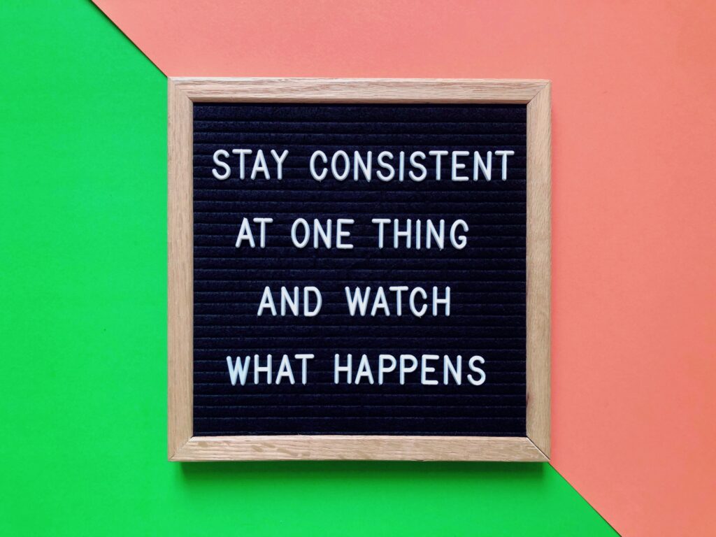 Wall board with the sentence: "Stay consistent at one thing and watch what happens"