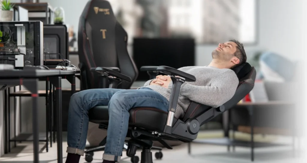 Gamer in a gaming chair, reclined almost into a laying position.