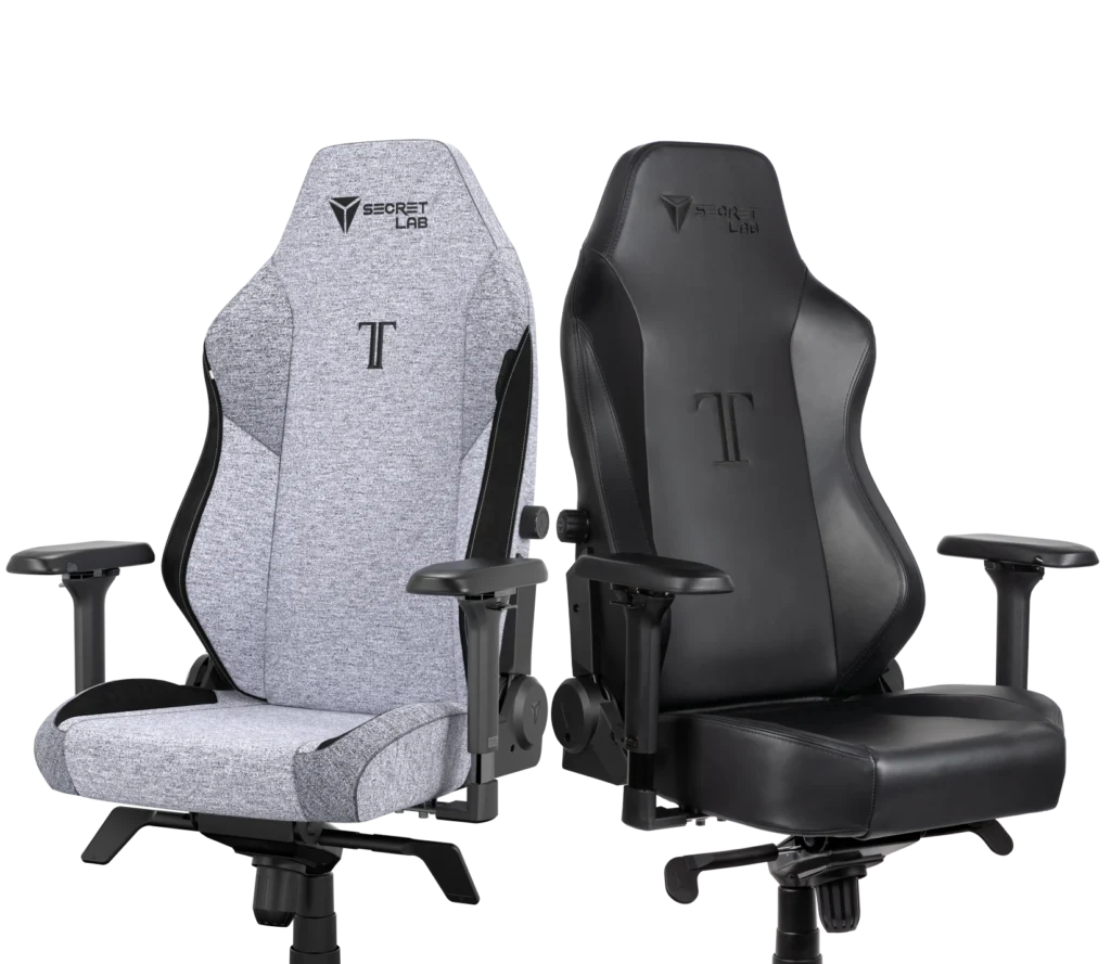 Two gaming chairs, one in black leather and another one in a grey fabric.