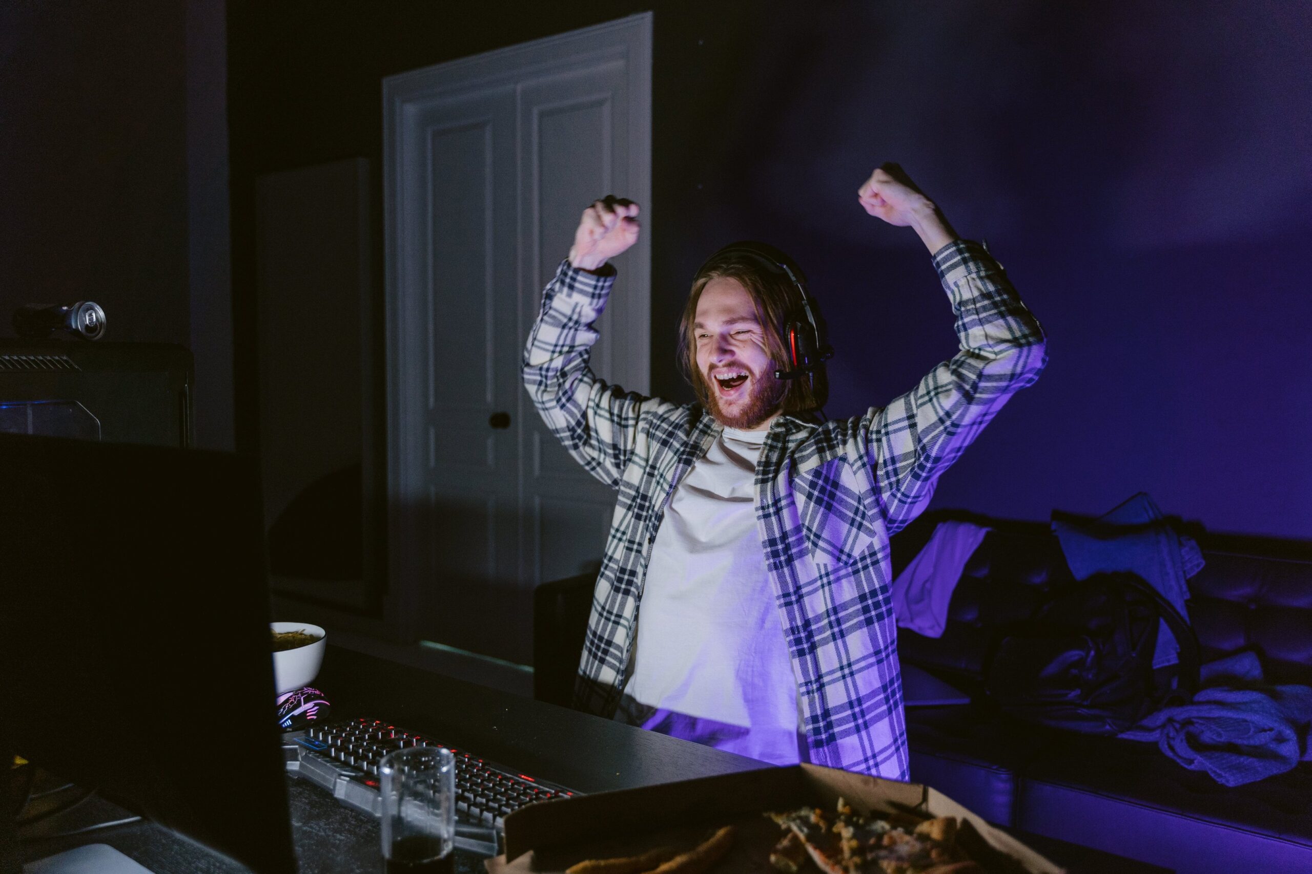 a man with a beard and a plaid shirt celebrating after winning on a video game